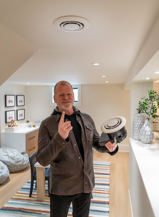 Mike Holmes holding air purifier