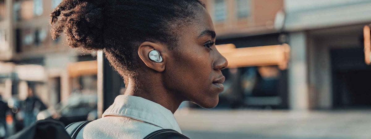 Women wearing Technics earbuds while walking on the street