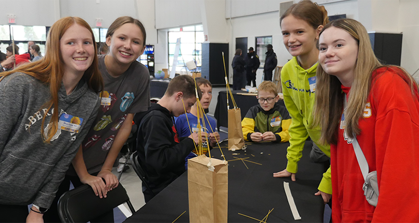 A group of students shows off their project at STEM Fest
