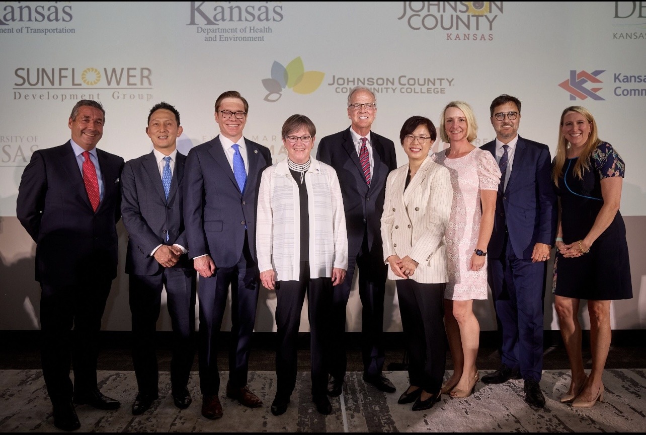 Kansas Governor Laura Kelly poses with Panasonic North America CEO Megan Myungwon Lee, along with their respective staff members