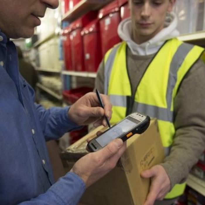 Man uses a Panasonic Android handheld to sign for a package