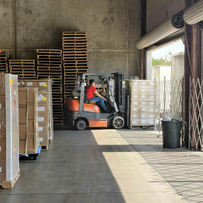a man operates a forklift inside a warehouse