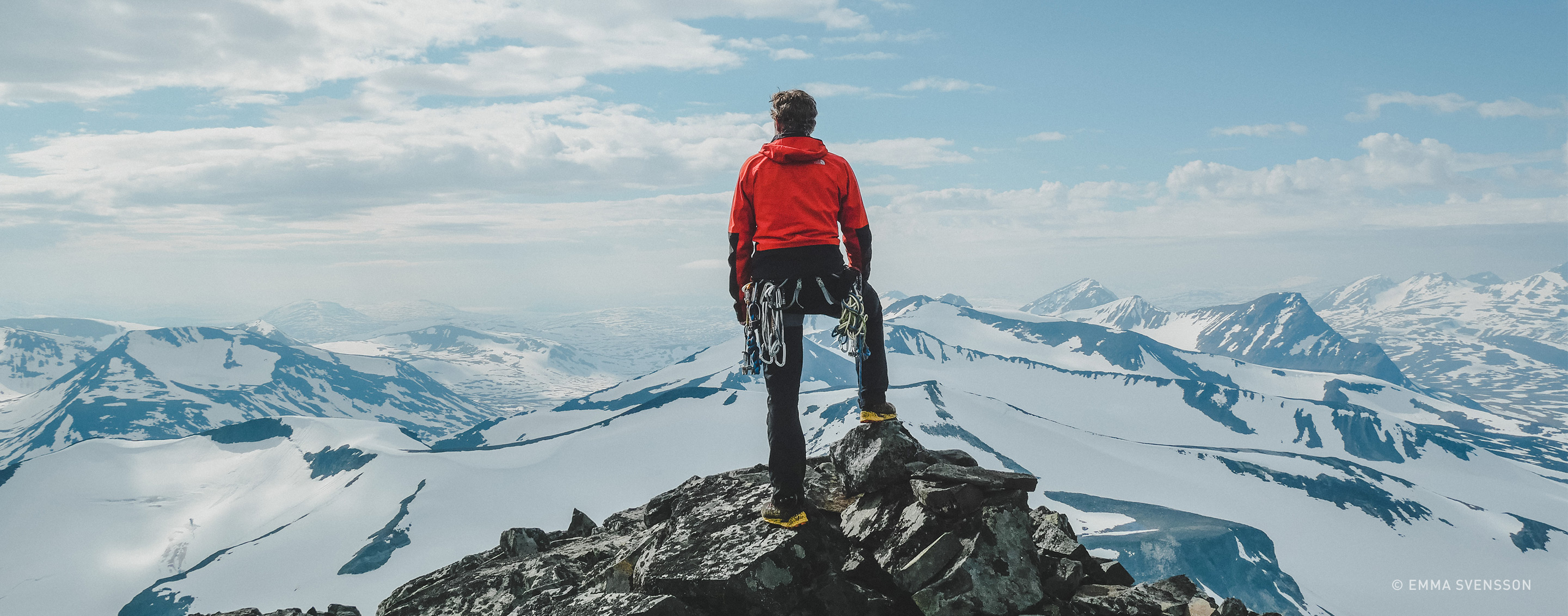 hiker standing on mountain peak with vista