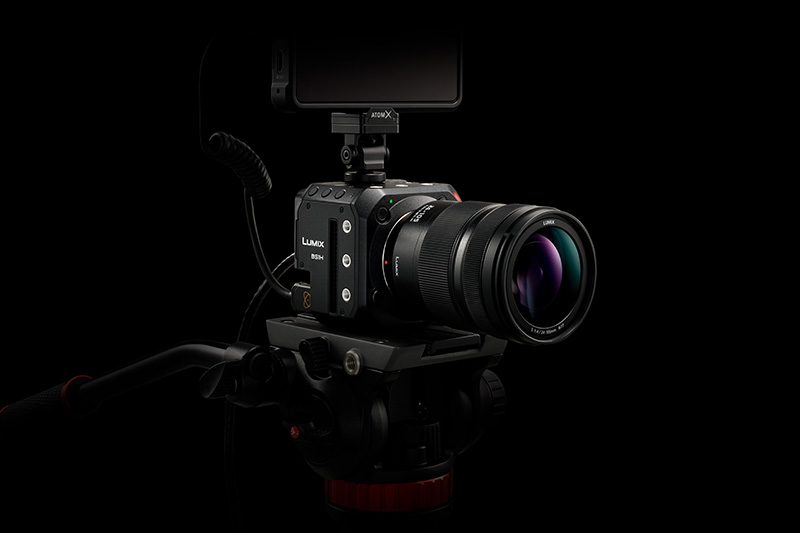 Against a black background, the BS1H mounted on a tripod with a monitor mounted to hot shoe