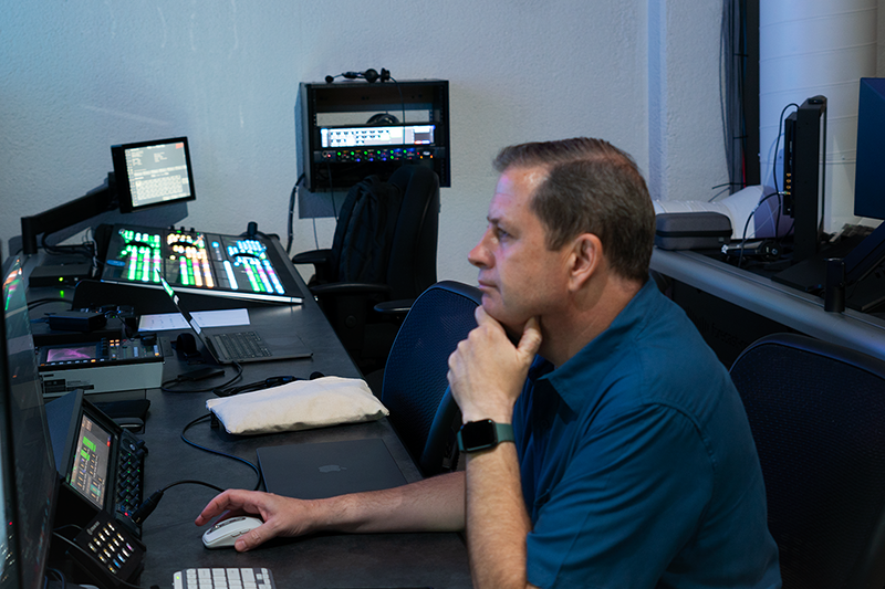 John Porterfield sitting at a desk controlling a church livestream broadcast