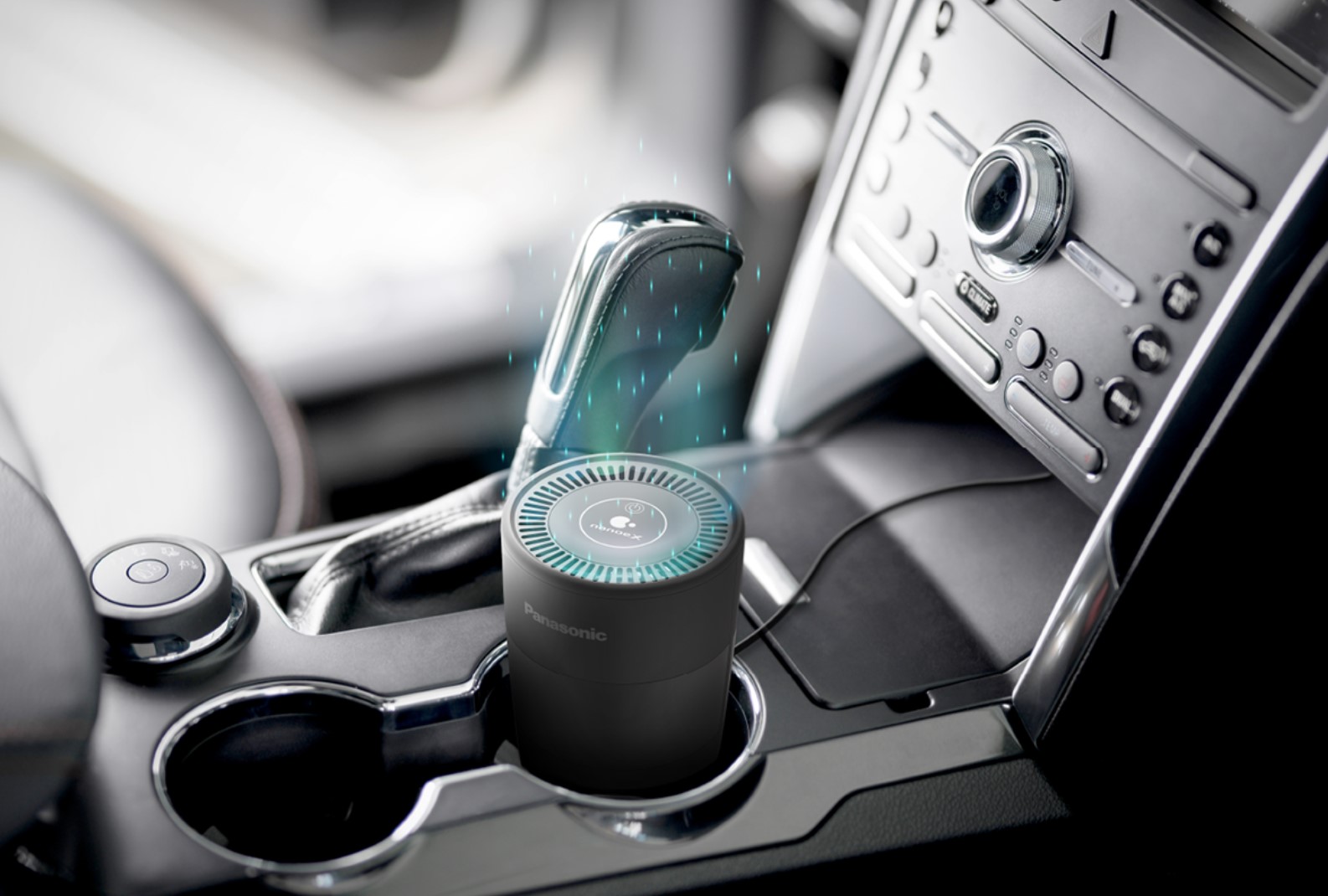 The Panasonic Automotive nanoeX air purifier rests in a vehicle cup holder