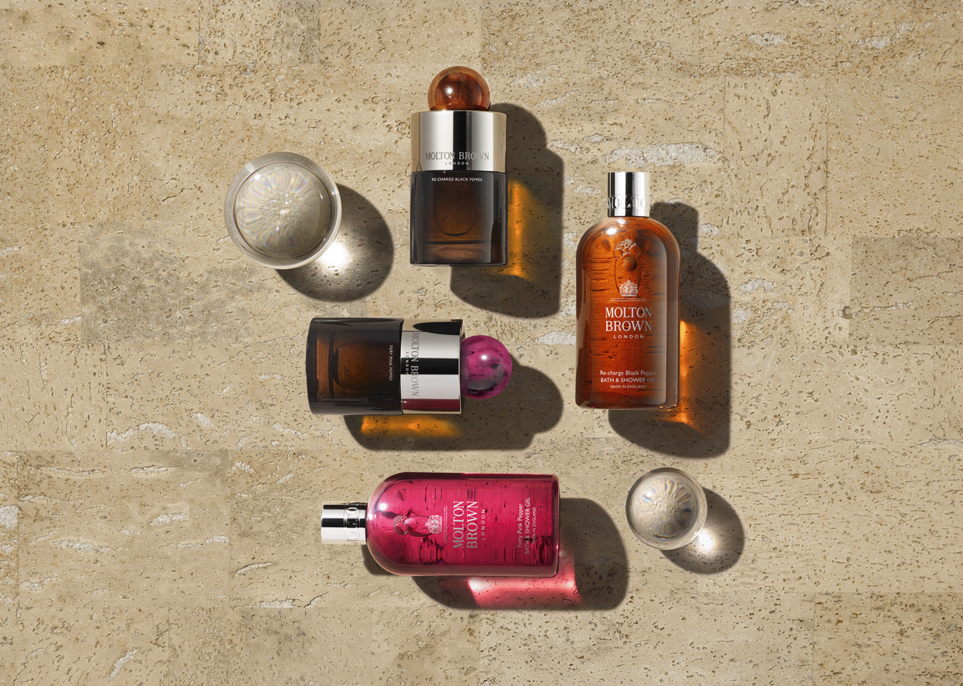 Overhead view showing a variety of travel-sized Bath & Shower Gels from Molton Brown