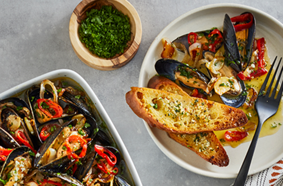 beauty shot of steamed mussels with chives and garlic bread