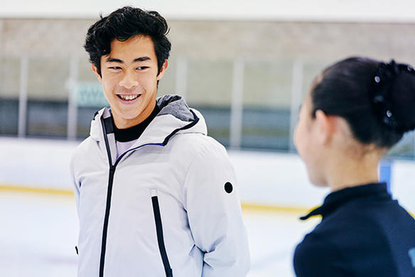Nathan Chen speaks with a woman on the ice