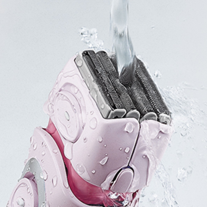 Close up of the ES2216PC personal groomer's shaving head, under running water. 