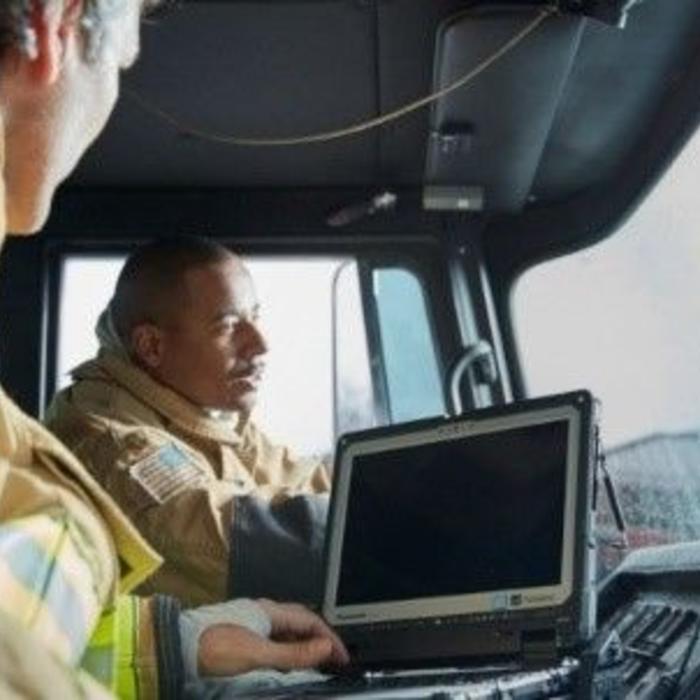 Two firefighters in truck with Panasonic TOUGHBOOK rugged computer