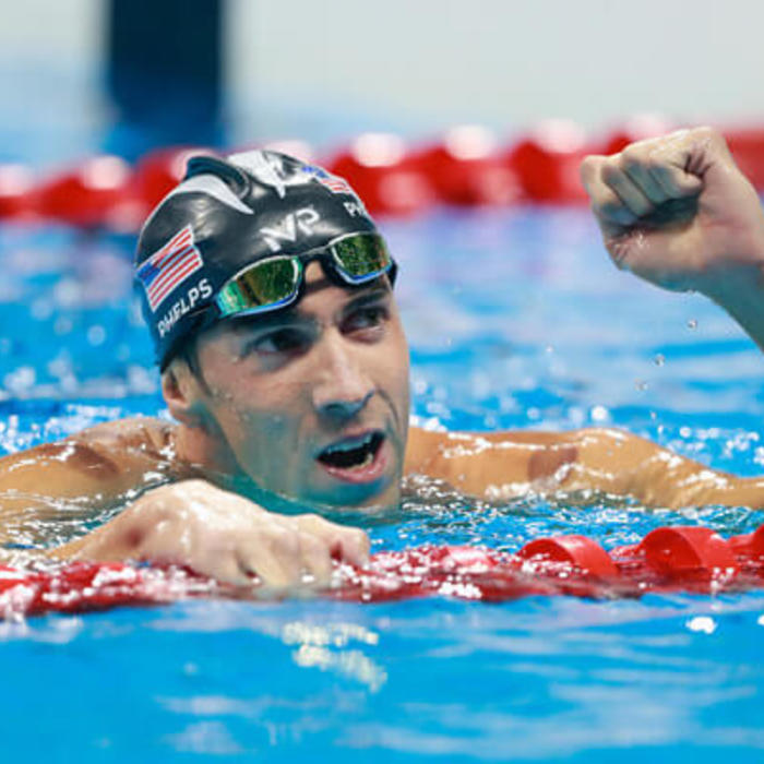 Michael Phelps pumps his fist in the pool upon seeing his race results