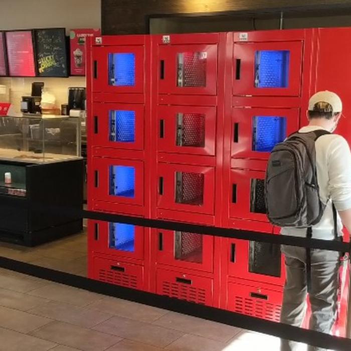 A man pick up an order at a smart locker terminal inside a restaurant