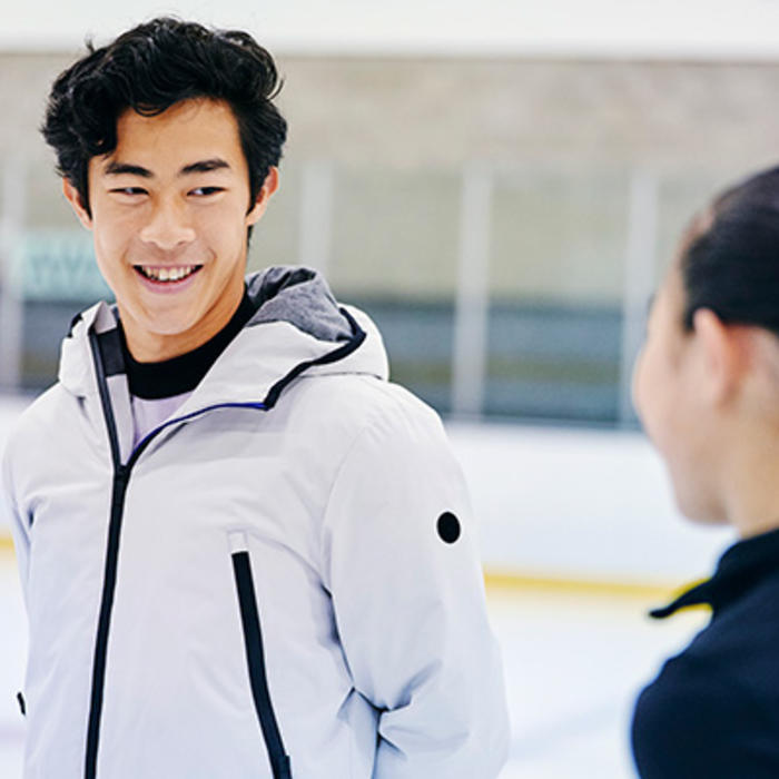 Nathan Chen speaks with a woman on the ice
