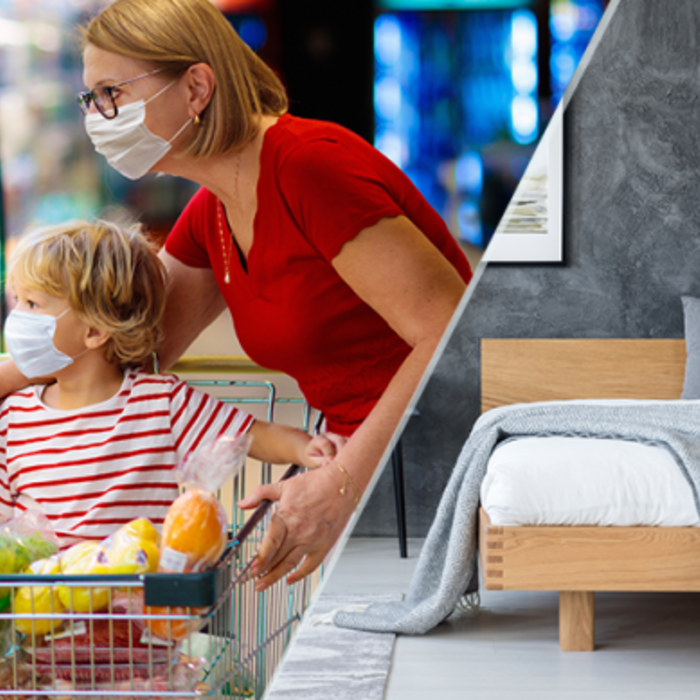 An image of a mother and son grocery shopping. They are wearing masks and the son rides in the shopping cart.