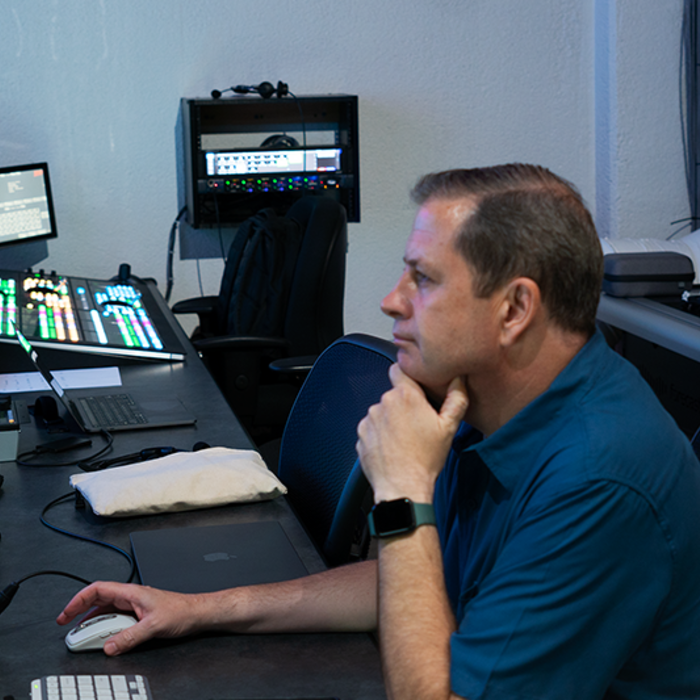 John Porterfield sitting at a desk controlling a church livestream broadcast