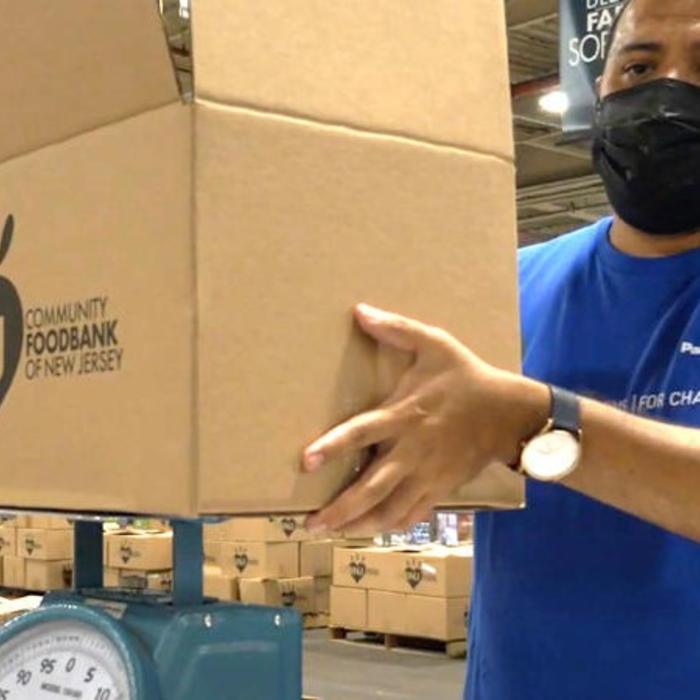 A Panasonic employee volunteer helps carry boxes at the Community Food Bank of New Jersey