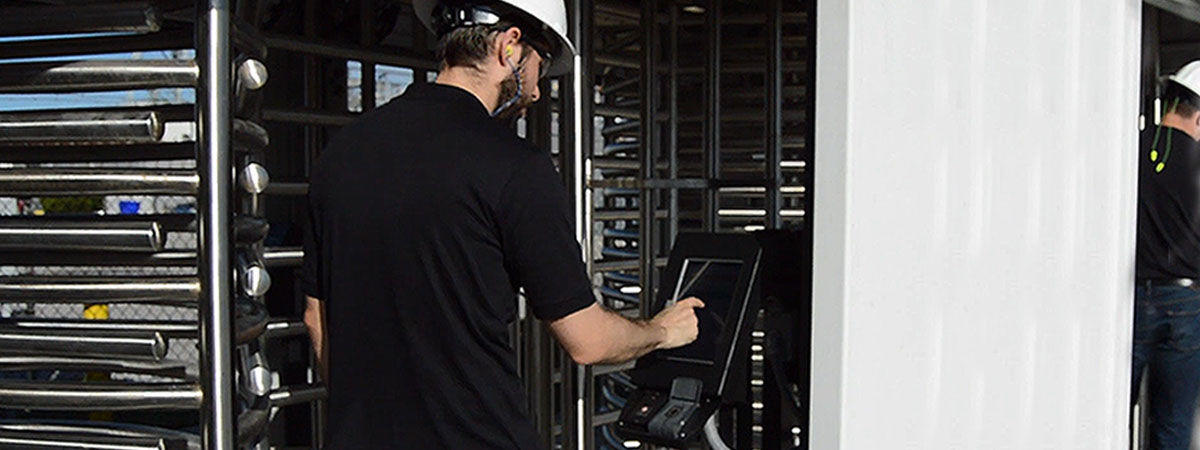 Man in hard hat uses Panasonic TOUGHPAD FZ-G1 in kiosk to enter gated jobsite