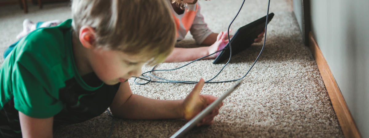 Children using tablets plugged into a dual charger