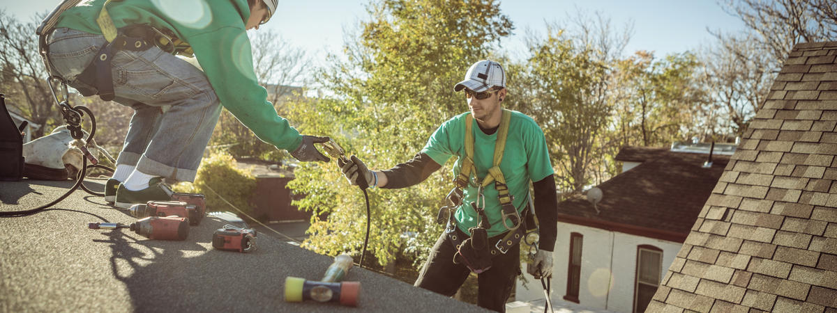 Solar panel installation crew members on roof of house