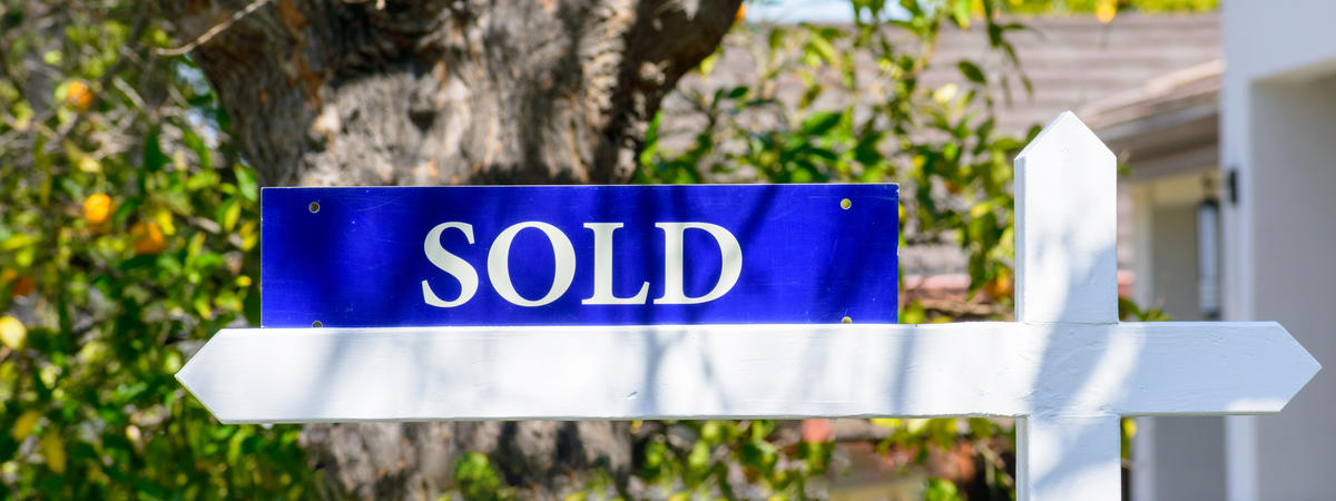 Sold real estate sign on wooden post