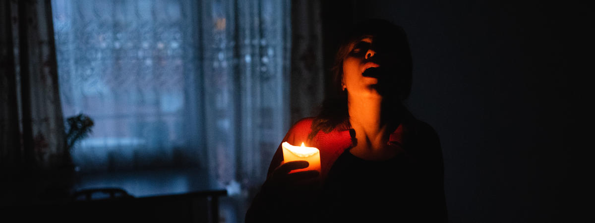 Woman with candle at home because of power cut