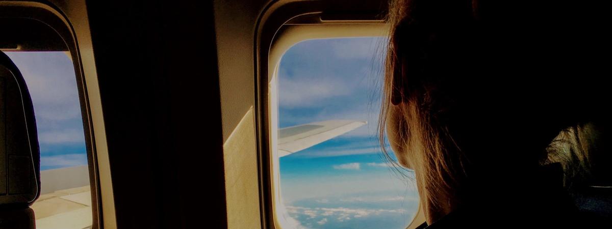 a woman looks out an airplane window